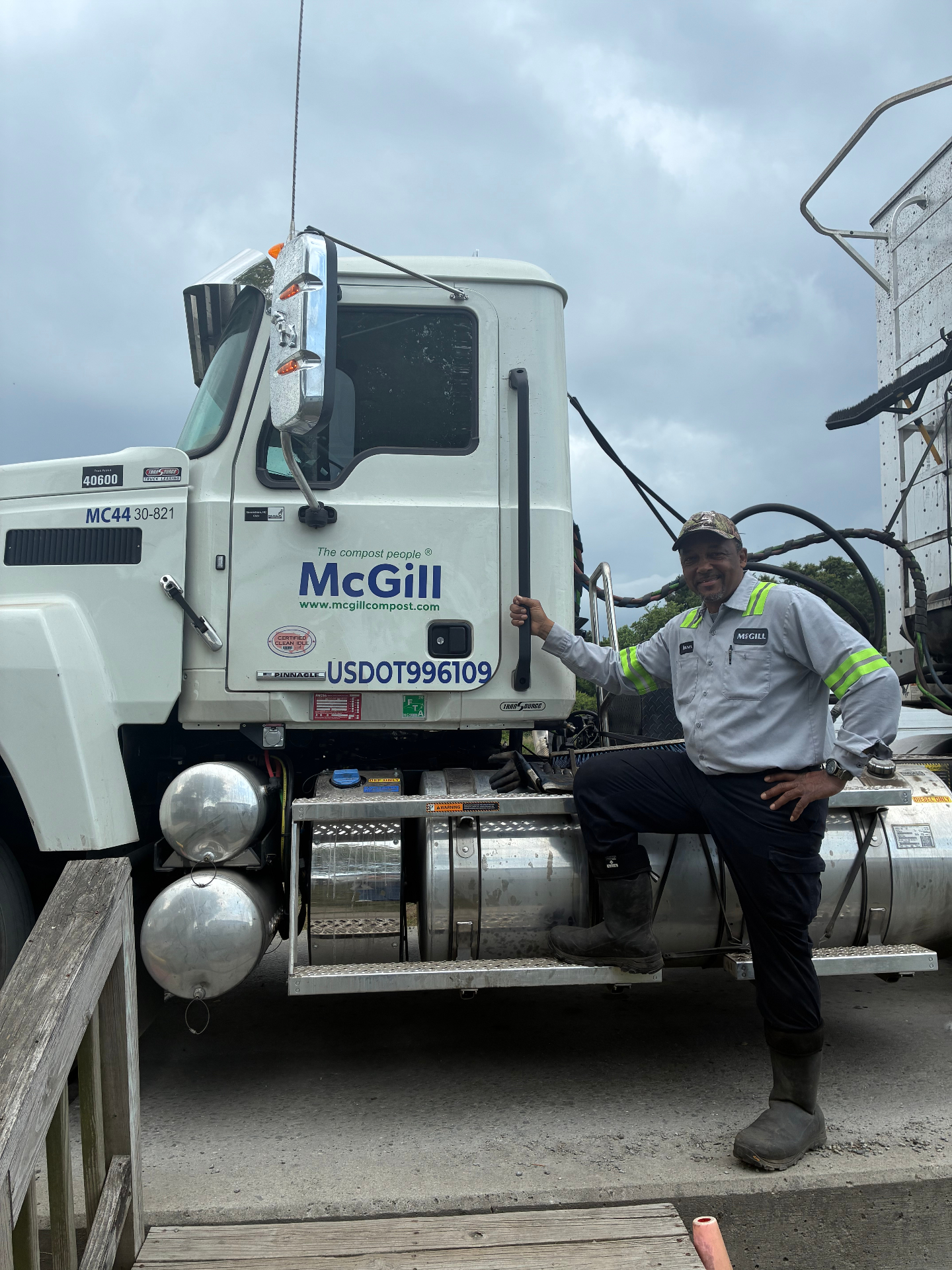 McGill driver smiling next to his Mack truck