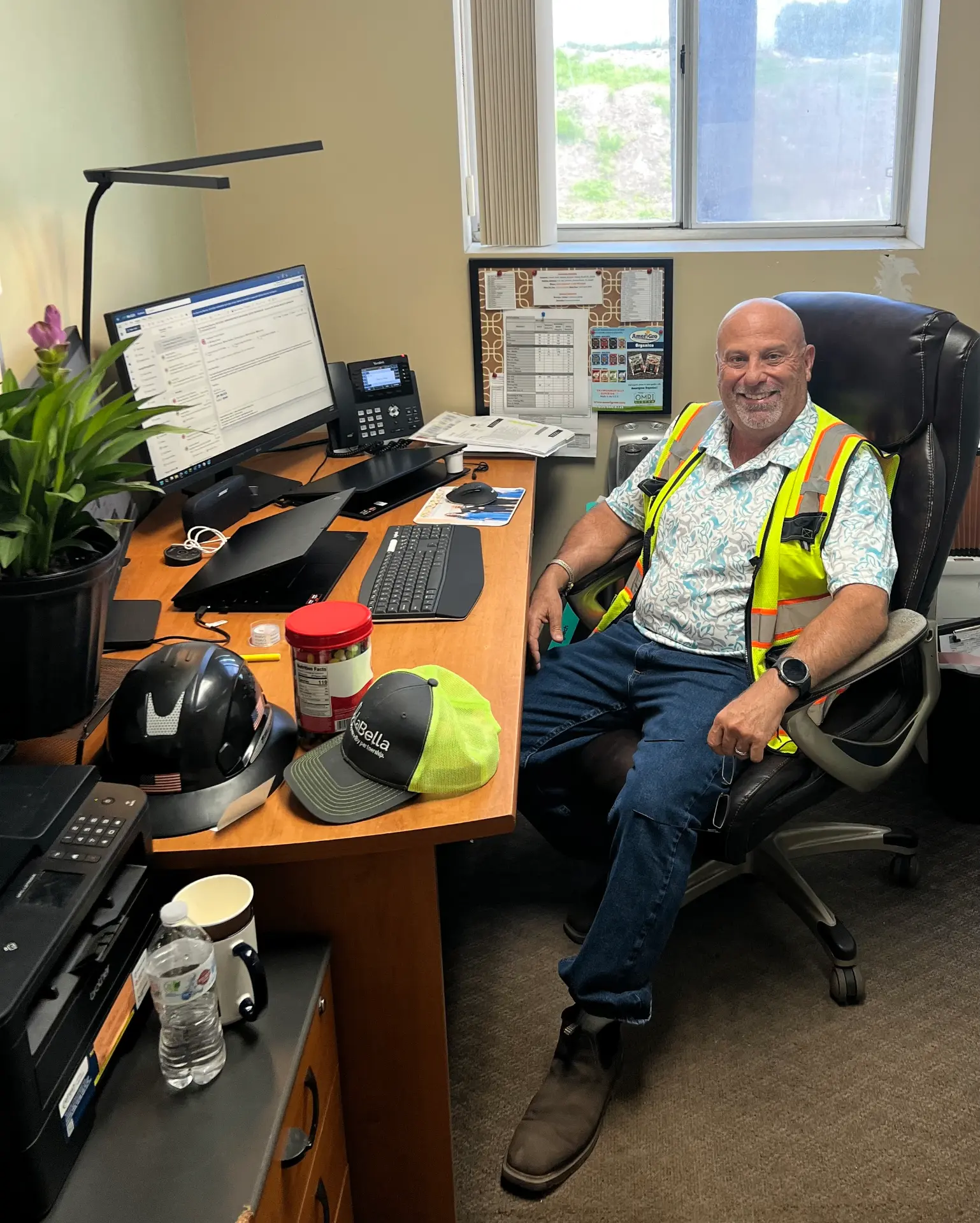 McGill plant manager smiling at his desk in a high-visibility safety vest