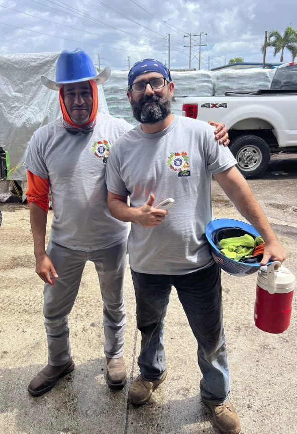 Two McGill team members smiling together in front of a McGill truck and product pallets