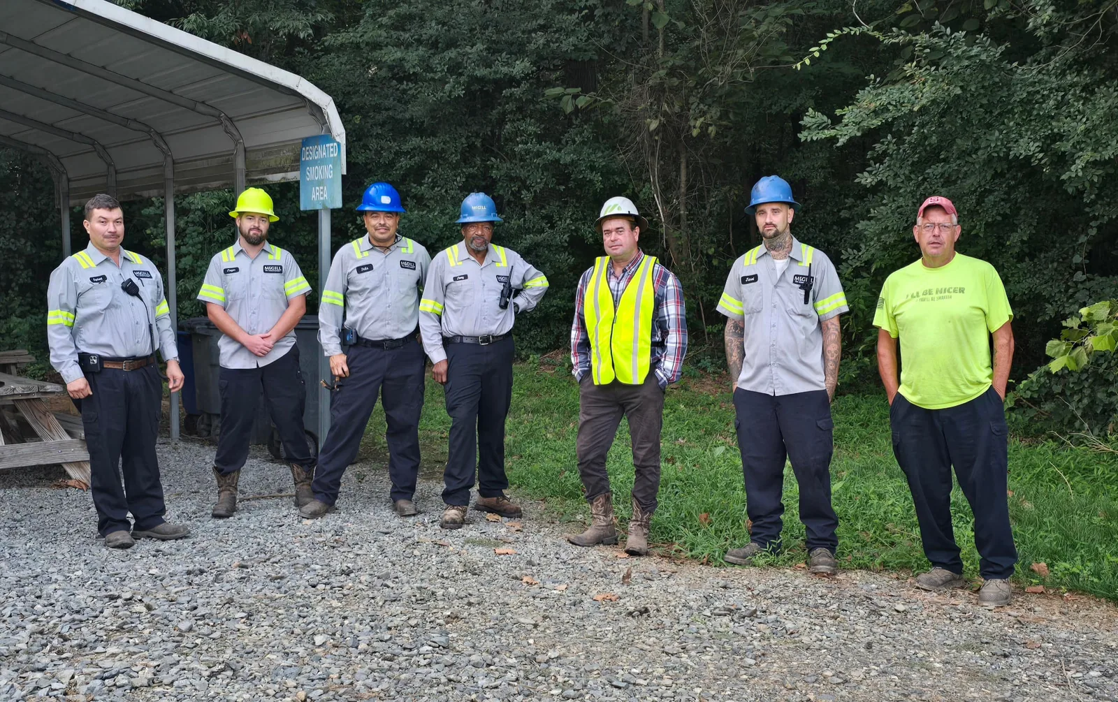 McGill team members in hard hats and safety gear lined up outside the plant